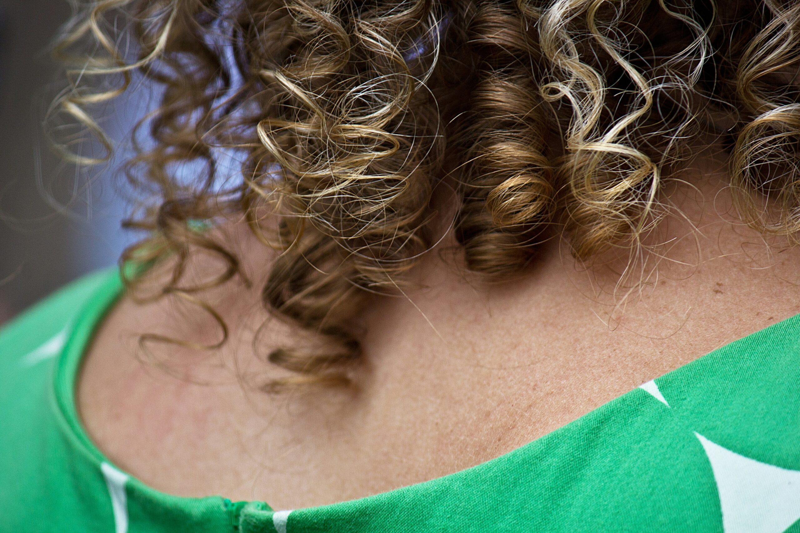 A woman wearing a braided updo adorned with floral hairpins.
