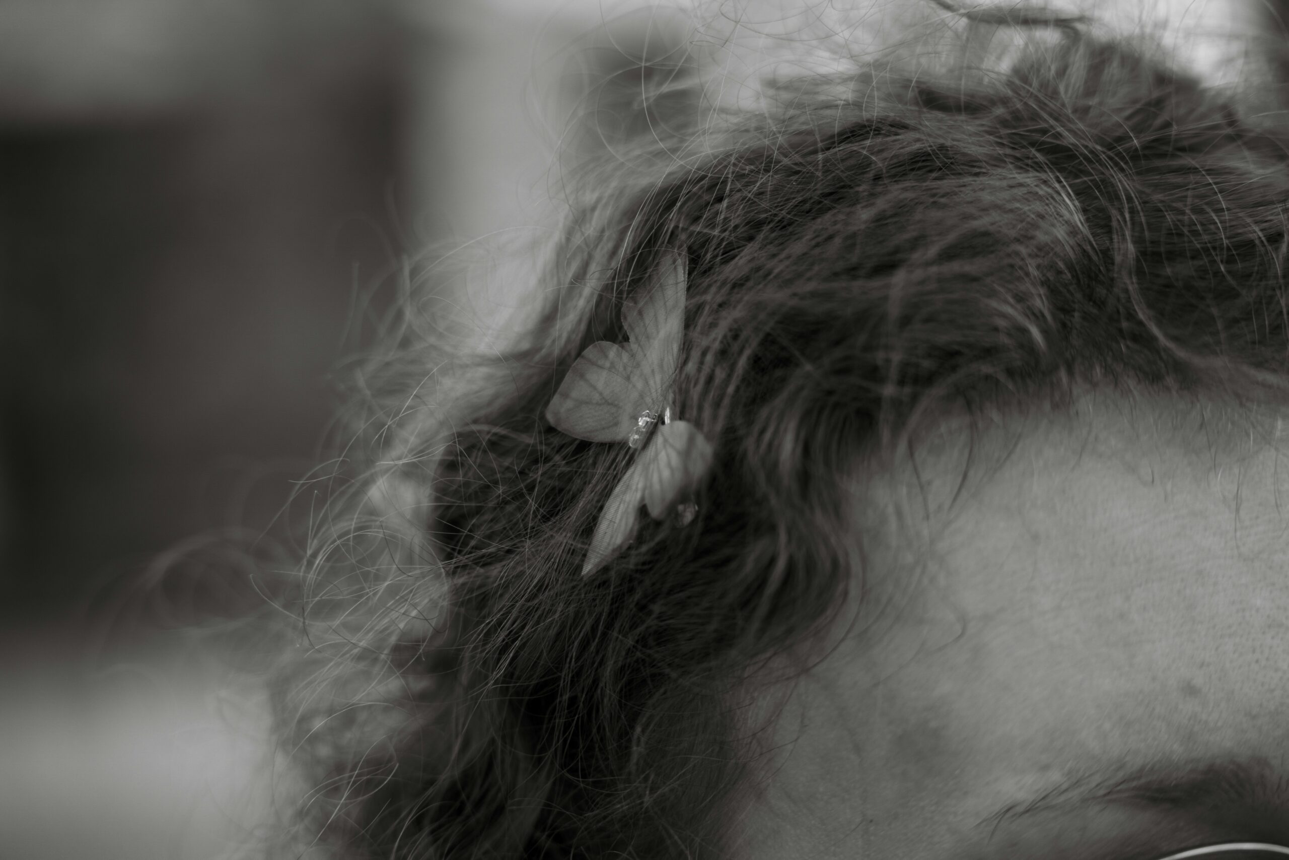 Close-up of hands braiding hair while inserting pearl pins.