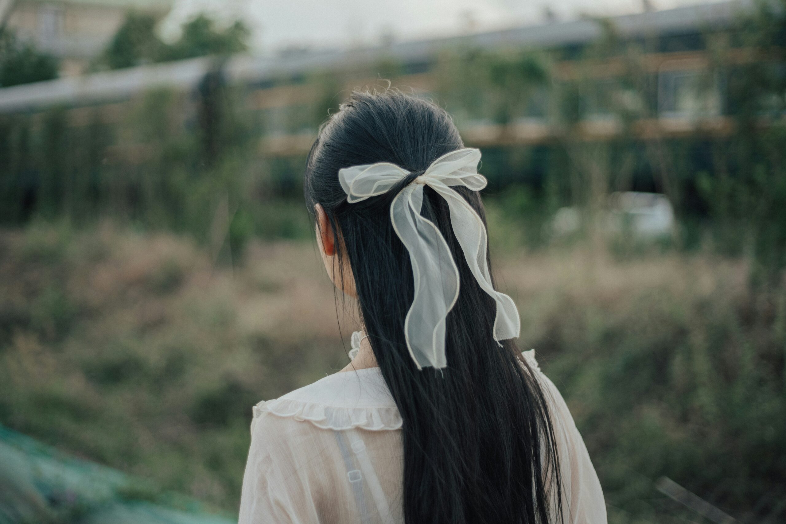 A woman struggling with loose hairpins while attempting a chignon.