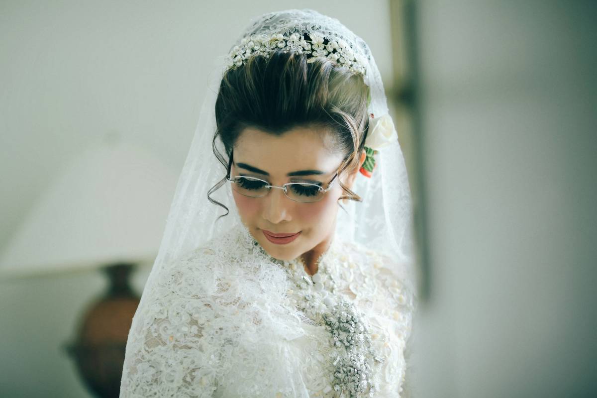 A model wearing a half-up hairstyle adorned with small white flowers for a bohemian bridal look.