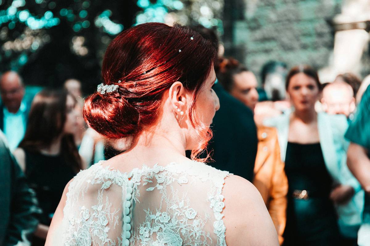 A woman preparing her hair with texturizing spray for a formal bun hairstyle.