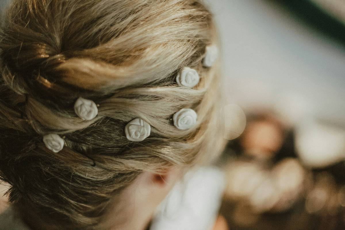 A woman creating a braided updo hairstyle section by section.