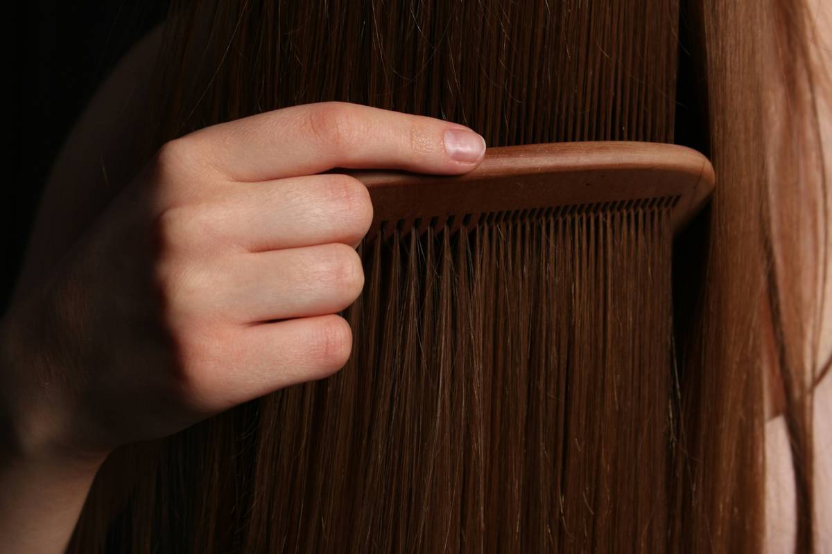 Bride preparing her hair with a brush and hairspray