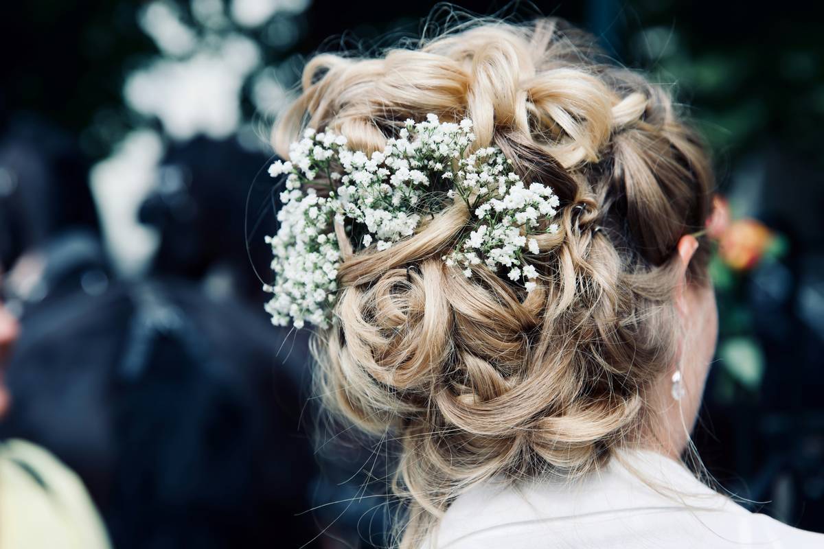 Close-up shot of hands creating a vintage chignon hairstyle with bobby pins.