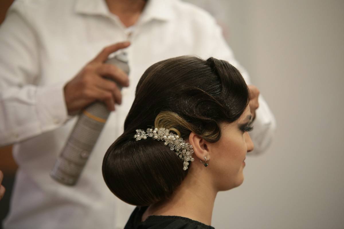 A step-by-step visual guide showing three stages of creating a classic low bun.